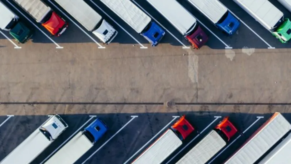 Vista aérea de carretas estacionadas em fileiras num pátio logístico